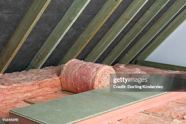 storage decking on top of fiberglass roof insulating material in attic - attic storage stockfoto's en -beelden