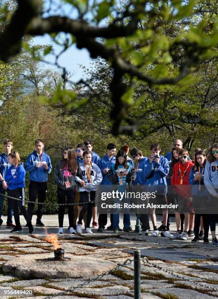 Group of visiting high school students stand at the gravesite of former U.S. President John F. Kennedy and his wife, Jacqueline Kennedy Onassis, and...