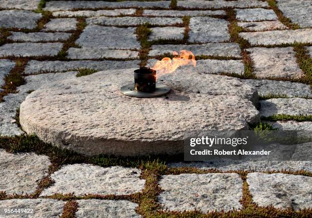 The John F. Kennedy Eternal Flame burns at the gravesite of former U.S. President John F. Kennedy and his wife, Jacqueline Kennedy Onassis, at...