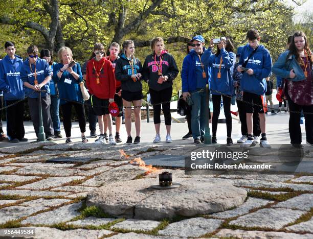 Group of visiting high school students stand at the gravesite of former U.S. President John F. Kennedy and his wife, Jacqueline Kennedy Onassis, and...