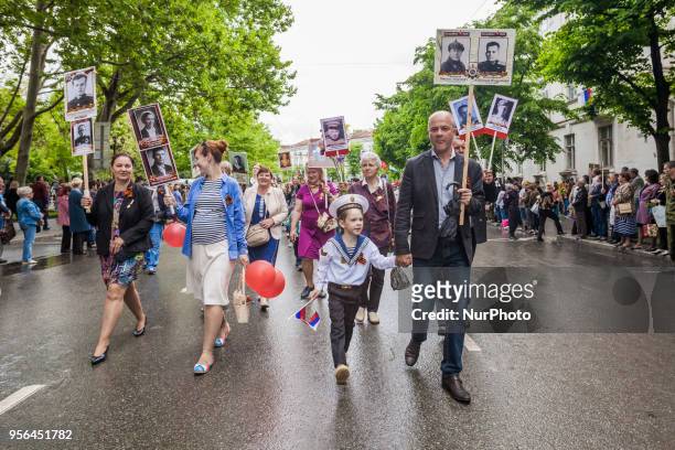 People march in a rally with photos of their relatives killed in Second World War during the celebration of 9th May in Sevastopol, Ukraine, on May 9,...