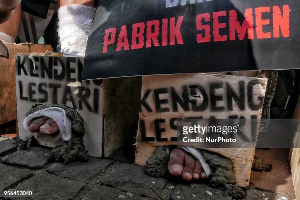 Demonstrators cement their foot as protest to German's Heidelberg cement factory in Kendeng in front of the German Embassy in Jakarta, Indonesia on...