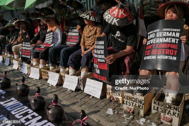 Demonstrators cement their foot as protest to German's Heidelberg cement factory in Kendeng in front of the German Embassy in Jakarta, Indonesia on...