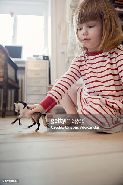 girl playing with a toy horse, sweden. - horses playing stock pictures, royalty-free photos & images