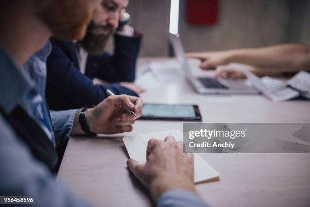 close up of a man taking notes on a business meeting - bank manager imagens e fotografias de stock