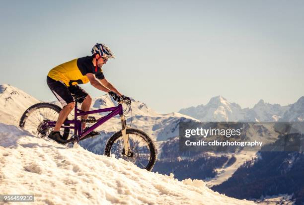 mountain biker riding on the snow - sports photographer stock pictures, royalty-free photos & images