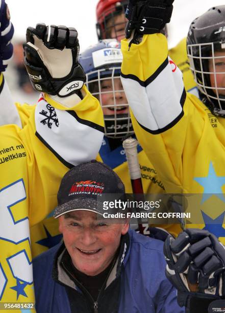 Canadian legend and head coach of the Russian ice hockey team HC Metallurg Magnitogorsk, Dave King poses with young hockey players 28 December 2005...