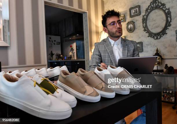 Syrian refugee Daniel Essa, former TV presenter in Damas, poses with the shoes he designed, in Villeneuve-d'Ascq, northern France on May 3, 2018. -...