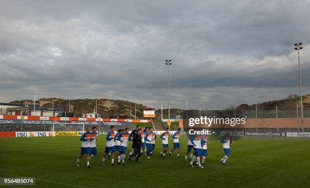 Dutch players Wout Brama , Peter Wisgerhof and Urby Emanuelson jog during a training a session of the Dutch national team in Katwijk on October 4,...