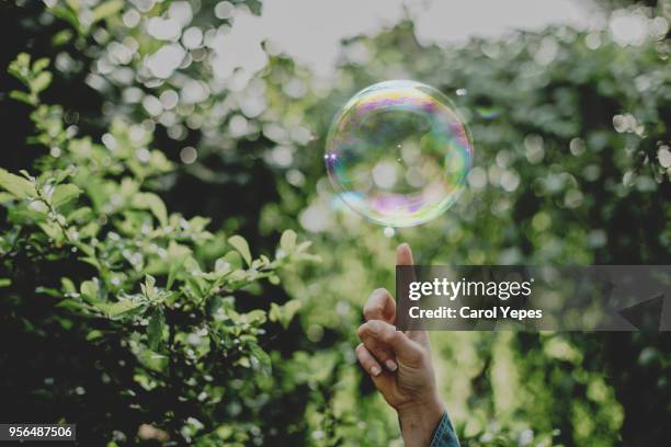 hand trying to catch  soap bubbles - ligero fotografías e imágenes de stock