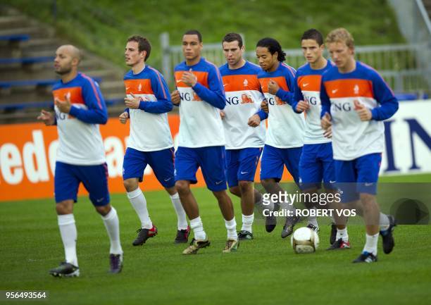 Dutch players Wout Brama , Peter Wisgerhof and Urby Emanuelson jog during a training a session of the Dutch national team in Katwijk on October 4,...