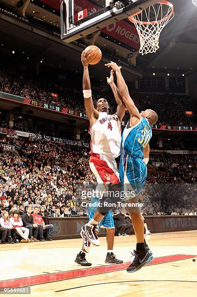 Chris Bosh of the Toronto Raptors goes to the basket against David West of the New Orleans Hornets during the game on December 20, 2009 at Air Canada...