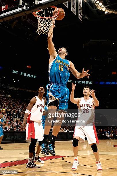 Peja Stojakovic of the New Orleans Hornets lays the ball up over Chris Bosh and Hedo Turkoglu of the Toronto Raptors during the game on December 20,...