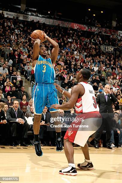 Chris Bosh of the New Orleans Hornets shoots over Marcus Banks of the Toronto Raptors during the game on December 20, 2009 at Air Canada Centre in...