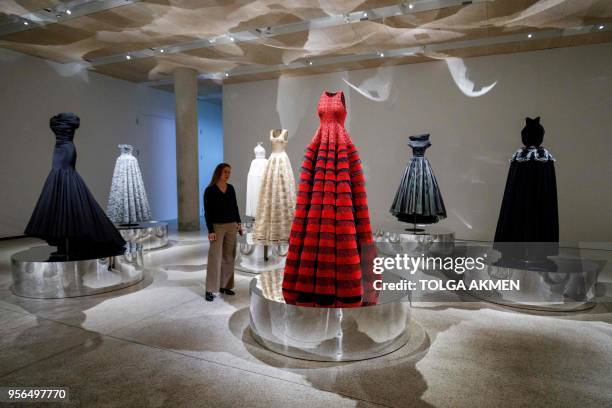 Gallery assistant poses for a photograph with dresses by Tunisian-born designer Azzedine Alaia, in a collection entitled "Exploring Volume 2017",...