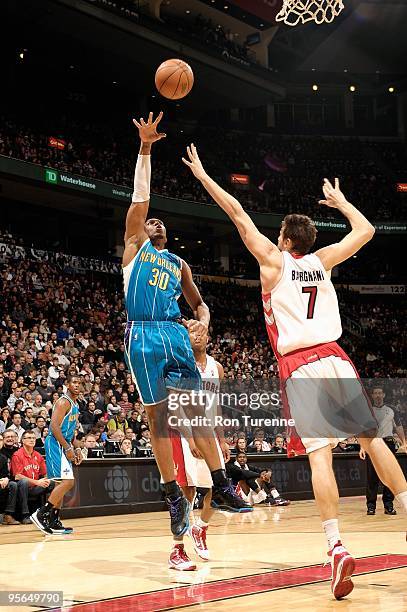 David West of the New Orleans Hornets puts a shot up over Andrea Bargnani of the Toronto Raptors during the game on December 20, 2009 at Air Canada...