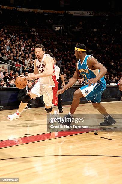 Hedo Turkoglu of the Toronto Raptors drives to the basket past Devin Brown of the New Orleans Hornets during the game on December 20, 2009 at Air...