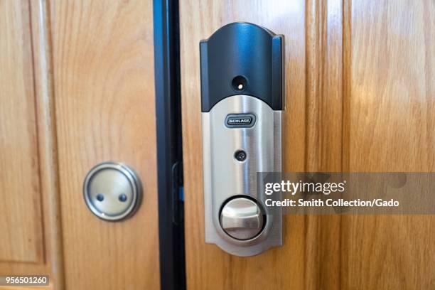 Close-up of Schlage Connect smart lock installed on the front door of a home, a smart home device which allows the door to be unlocked remotely from...