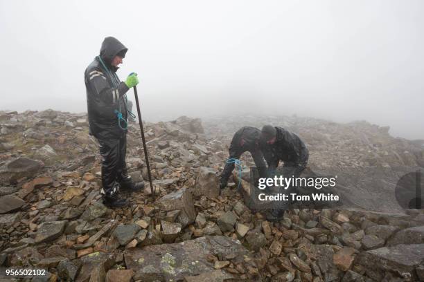 National Trust rangers haul huge rocks to help rebuild the summit cairn and World War I memorial at Scafell Pike on May 9, 2018 in Seascale, England....