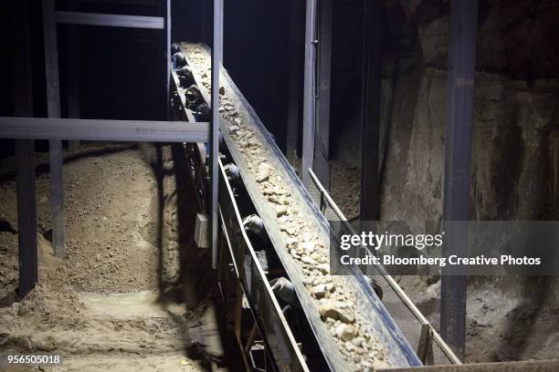 a vibrating feeder separates large chunks of rock from the silica sand - silicaat stockfoto's en -beelden