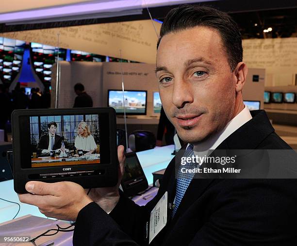 Coby Electronics Corp. Senior Product Marketing Manager Michael Paladino holds the company's eight-inch portable widescreen LCD television at the...