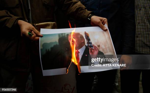 Iranians burn an image of US President Donald Trump during an anti-US demonstration outside the former US embassy headquarters in the capital Tehran...