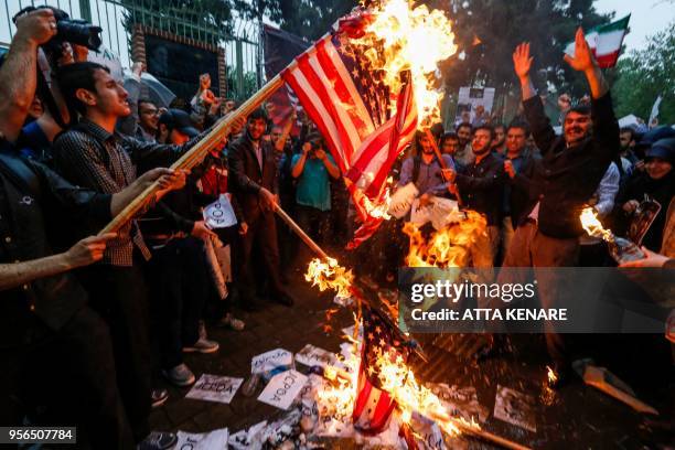 Iranians burn US flags during an anti-US demonstration outside the former US embassy headquarters in the capital Tehran on May 9, 2018. - Iranians...