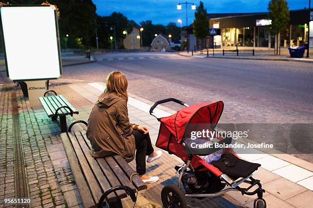 woman waiting on a bench with a baby carriage, sweden. - mother stroller stock pictures, royalty-free photos & images