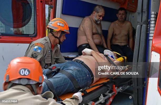 Emergency services attend to a man involved in a helicopter crash in Barra de Tijuca, Rio de Janeiro, Brazil on May 9, 2018. - One person was killed...