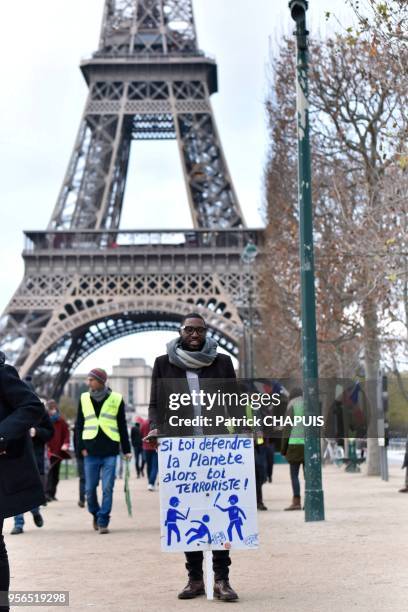 Jeune homme avec une pancarte contre l'état d'urgence et l'inscription 'si toi défendre la planète, alors toi terroriste' lors de la manifestation...