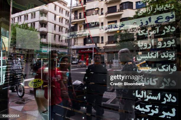 Commuters look at a blank currency exchange rate screen in the window of a closed bureau in Tehran, Iran, on Wednesday, May 9, 2018. U.S. President...