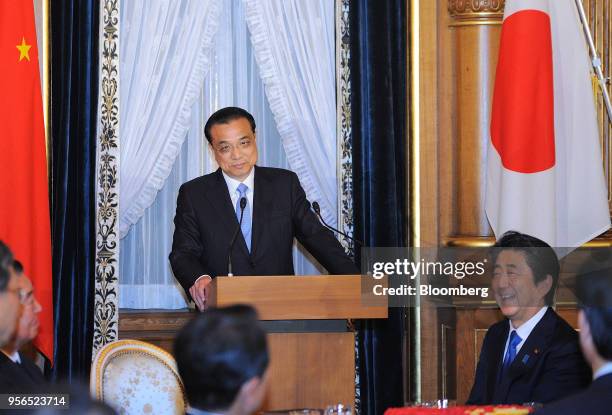 Li Keqiang, China's premier, pauses whilst at the podium as Shinzo Abe, Japan's prime minister, right, reacts during a joint news conference...