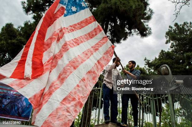 Iranians hold up an American flag before burning it during an anti-U.S. Demonstration outside the former U.S. Embassy headquarters in Tehran, Iran,...