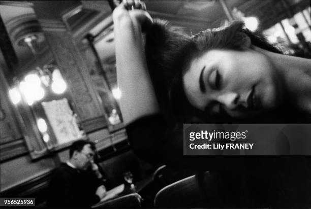Jeune femme se recoiffant dans le café 'La tartine', balade poétique Paris, France. Photo extraite d'une exposition inspirée du poème...