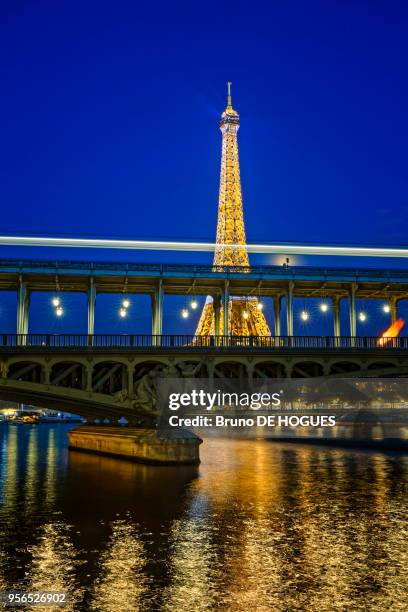 Tour Eiffel avec son éclairage scintillant, Pont Bir-Hakeim et le métro aérien à Paris, France.