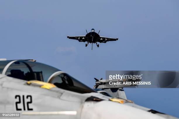 Hornet fighter jet prepares to land on the deck of the US navy aircraft carrier USS Harry S. Truman in the eastern Mediterranean Sea on May 8, 2018....