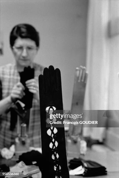 La main humaine étire un gant, des gants Christian Dior en agneau velours qui se dressent sur une main chauffante dans les Ateliers Agnelle le 11...