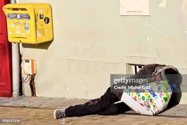 Sans abri couché sur un trottoir près d'une boite aux lettres le 14 Janvier 2017 dans le centre ville du Mans, Sarthe, France.