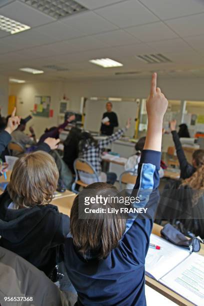 Elèves levant le doigt dans une classe de 6ème technologie, janvier 2000, collège Rosa Park à Gentilly, Val-de-Marne, France.