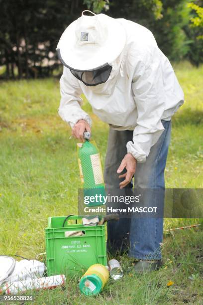 Un apiculteur avec une vareuse de protection prépare un produit pour détruire un nid de frelons asiatiques, 10 aout 2009, Lot-et-Garonne, France.