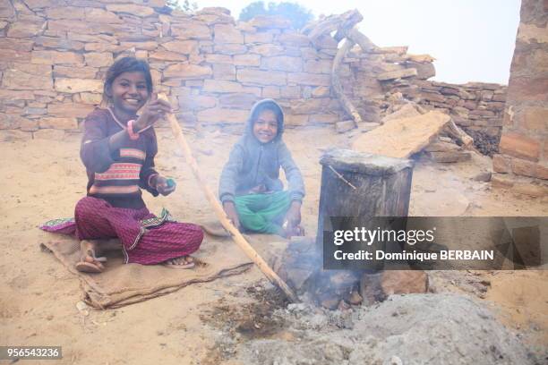 Fillettes faisant cuire de la nourriture sur 'un feu de bois, 1er janvier 2017, Jaisalmer, Rajasthan, Inde.