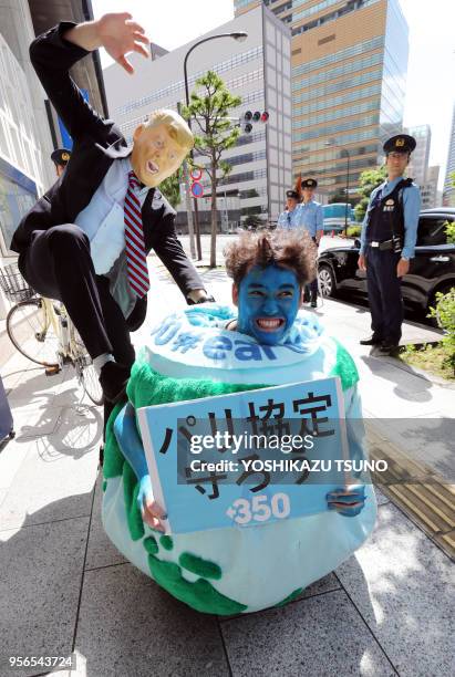 Des membres des assocoiations de défense de l'environnement Greenpeace et 350.org protestent contre la décision du président américain Donald Trump...