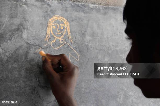 Elève indien dessinant un personnage à la craie lors d?un atelier organisé par une ONG locale à des enfants défavorisés à Udaipur, dans l'état du...