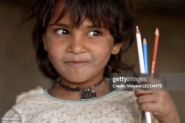 Enfant indien brandissant ses crayons de couleur lors d?un cours de dessin donné par une ONG locale à des enfants défavorisés à Udaipur, dans l'état...