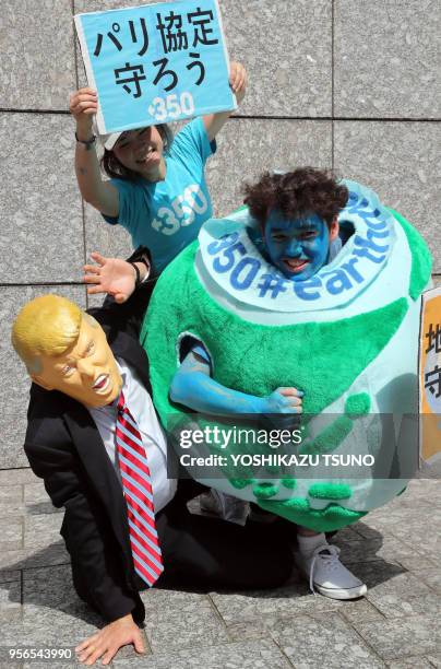 Des membres des assocoiations de défense de l'environnement Greenpeace et 350.org protestent contre la décision du président américain Donald Trump...