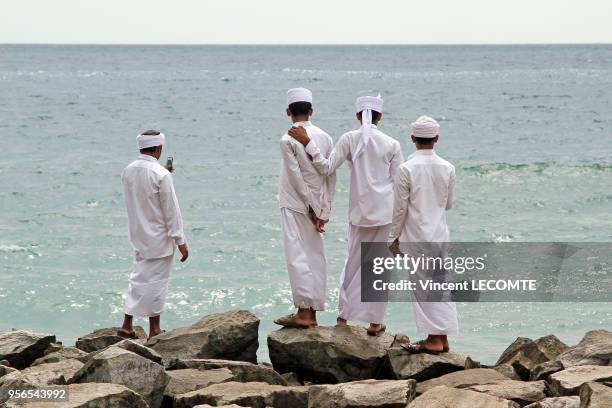 Quatre jeunes hommes musulmans en tenue traditionnelle regardant l?Océan Indien à Varkala, dans l'état du Kerala, en Inde, le 10 février 2012.
