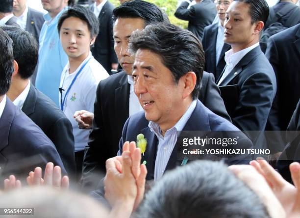 Japanese Prime Minister and ruling Liberal Democratic Party leader Shinzo Abe shakes hands with his supporters after he delivered a campaign speech...