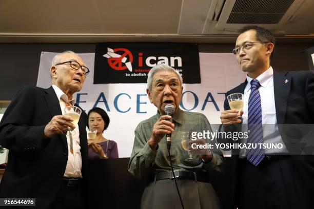 Japan's NGO Peaceboat co-founder Akira Kawasaki toasts with A-bomb survivors Nobuo Miyake and Terumi Tanaka as an international NGO International...
