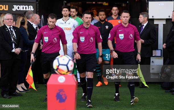 The match officials enter the pitch before the Premier League match between Swansea City and Southampton at Liberty Stadium on May 8, 2018 in...