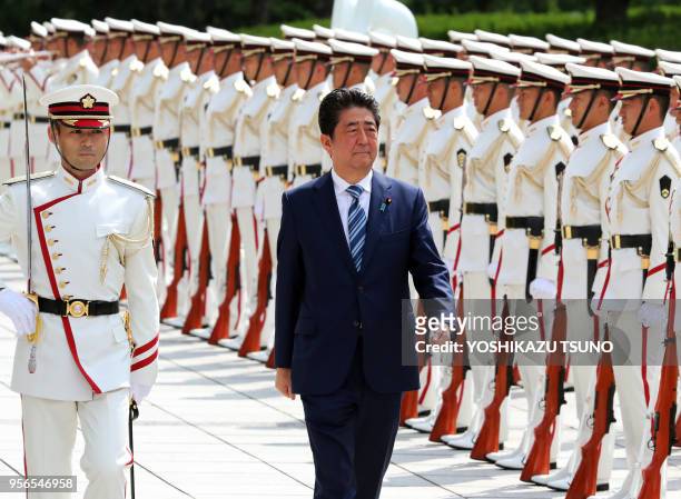 Japanese Prime Minister Shinzo Abe reviews the honor guards at the Defense Ministry in Tokyo on September 11, 2017. Abe and Defense Minister Itsunori...
